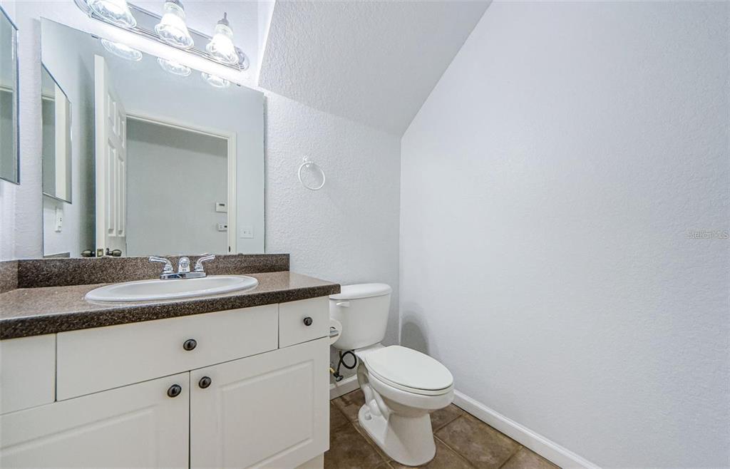 2148 Chianti Place, Unit 1310 Palm Harbor, FL 34683 - Photo 14 of 33 a bathroom with a granite countertop toilet a sink and a mirror