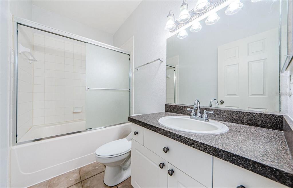 2148 Chianti Place, Unit 1310 Palm Harbor, FL 34683 - Photo 18 of 33 a bathroom with a granite countertop sink toilet and shower