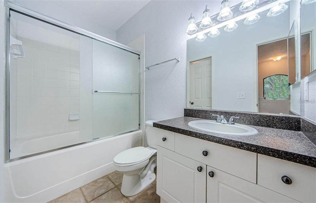 2148 Chianti Place, Unit 1310 Palm Harbor, FL 34683 - Photo 19 of 33 a bathroom with a granite countertop sink a toilet and shower