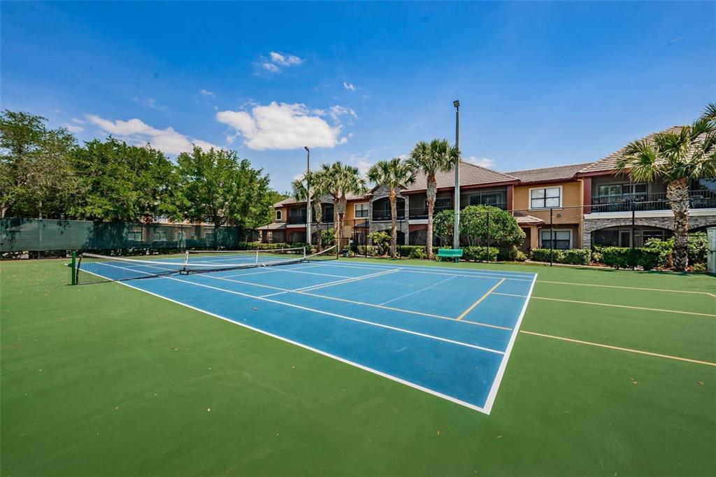 2148 Chianti Place, Unit 1310 Palm Harbor, FL 34683 - Photo 22 of 33 a view of a tennis ground with large trees