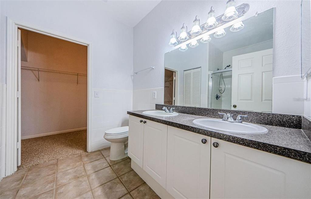 2148 Chianti Place, Unit 1310 Palm Harbor, FL 34683 - Photo 6 of 33 a bathroom with a granite countertop sink a toilet and a mirror