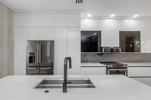 a kitchen with a sink and stainless steel appliances