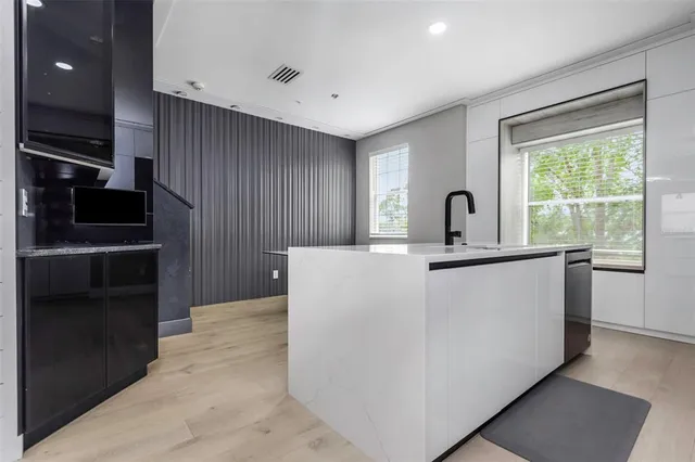 a living room with a large window and stainless steel appliances