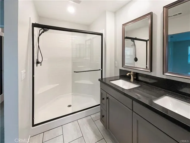 a bathroom with a granite countertop sink mirror and a shower