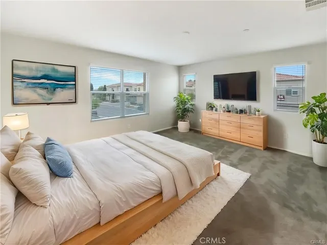 a bedroom with a large bed and a flat screen tv