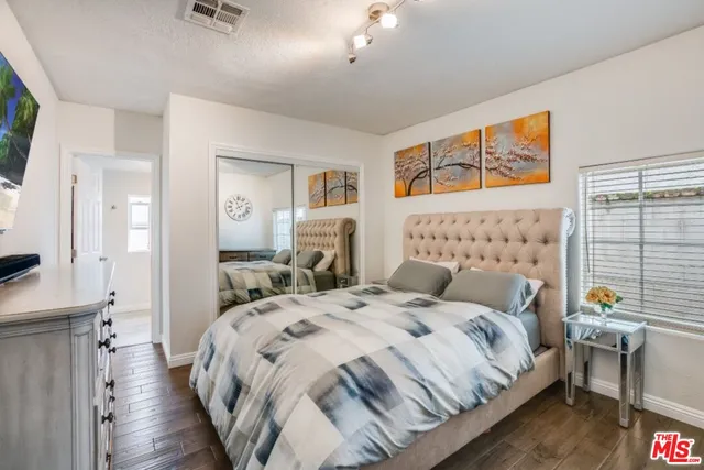 a bedroom with bed and wooden floor