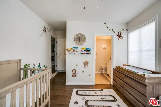 a room with lots of white furniture and wooden floor