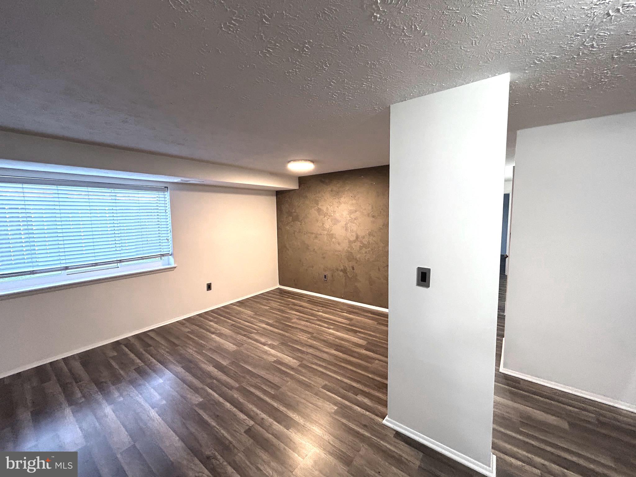 12405 Hickory Tree Way, Unit 613 Germantown, MD 20874 - Photo 17 of 39 a view of an empty room with wooden floor and a window