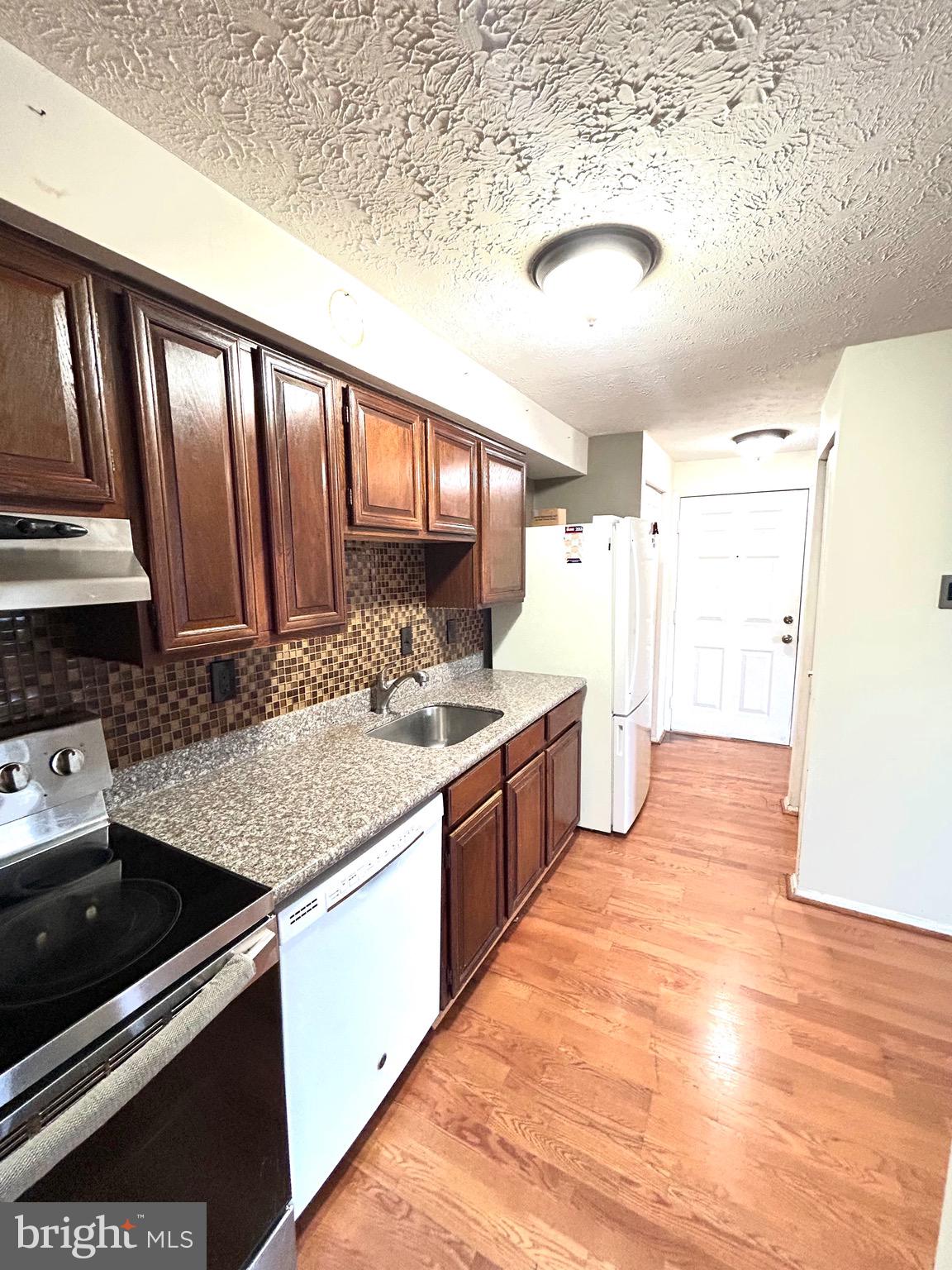 12405 Hickory Tree Way, Unit 613 Germantown, MD 20874 - Photo 17 of 22 a large kitchen with stainless steel appliances granite countertop a stove and a sink