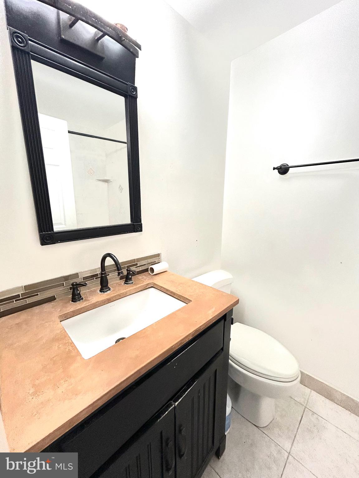 12405 Hickory Tree Way, Unit 613 Germantown, MD 20874 - Photo 19 of 22 a bathroom with a granite countertop sink mirror vanity and toilet