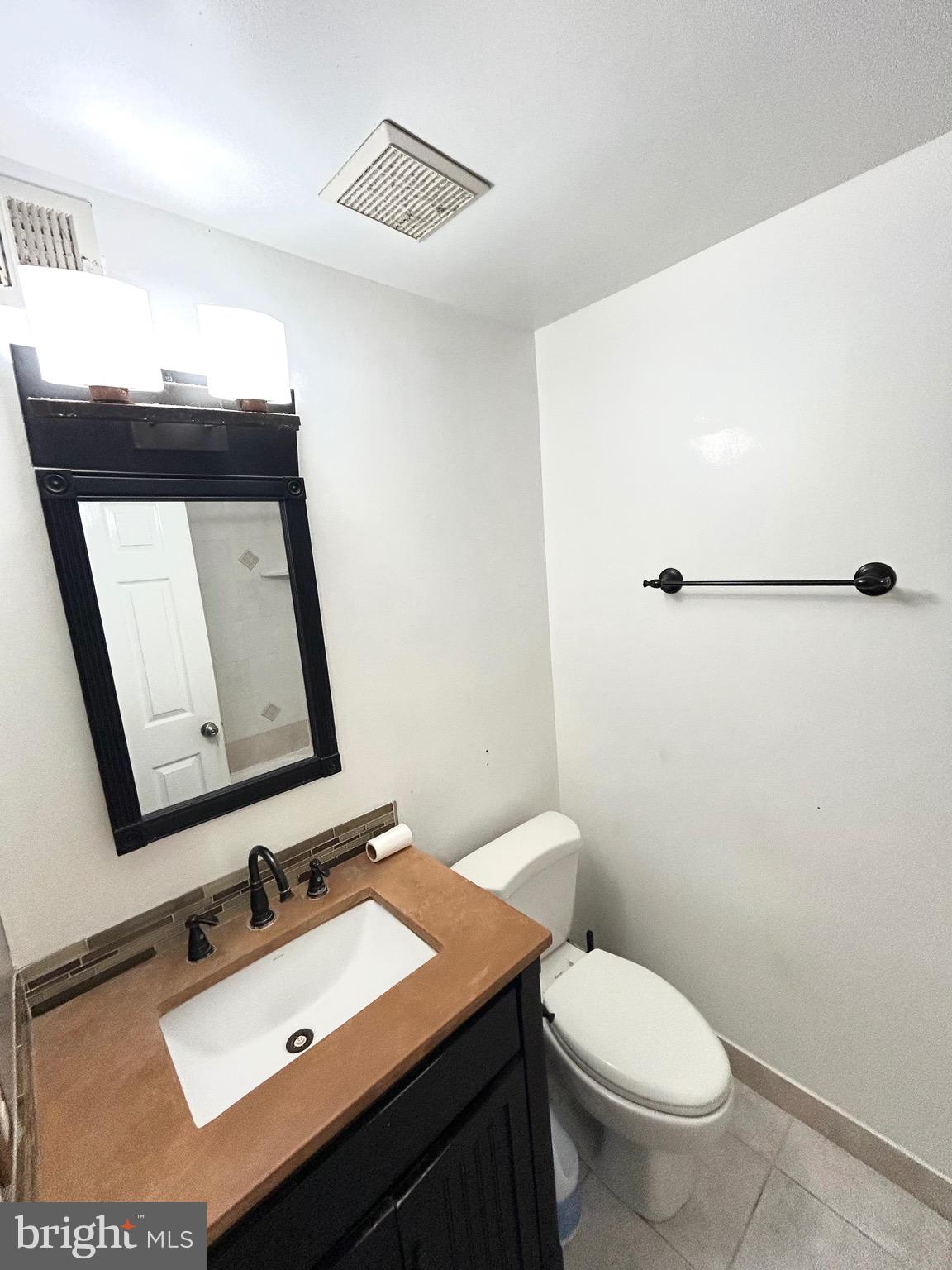 12405 Hickory Tree Way, Unit 613 Germantown, MD 20874 - Photo 20 of 22 a bathroom with a toilet sink and mirror