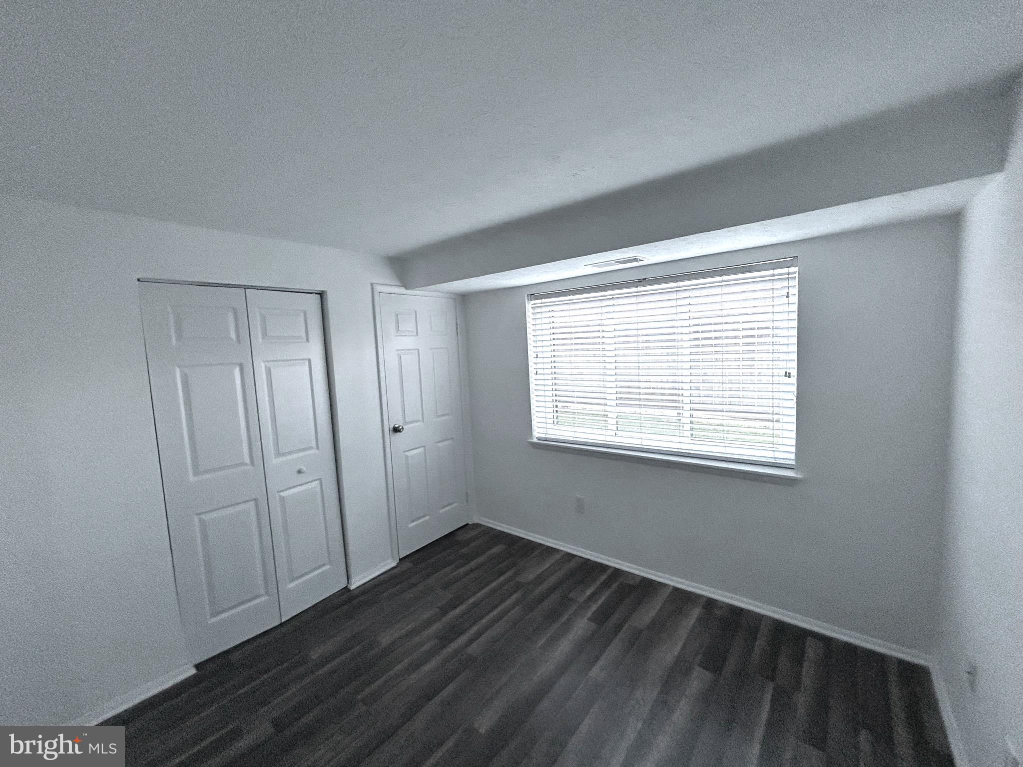 12405 Hickory Tree Way, Unit 613 Germantown, MD 20874 - Photo 21 of 39 a view of an empty room with wooden floor and a window