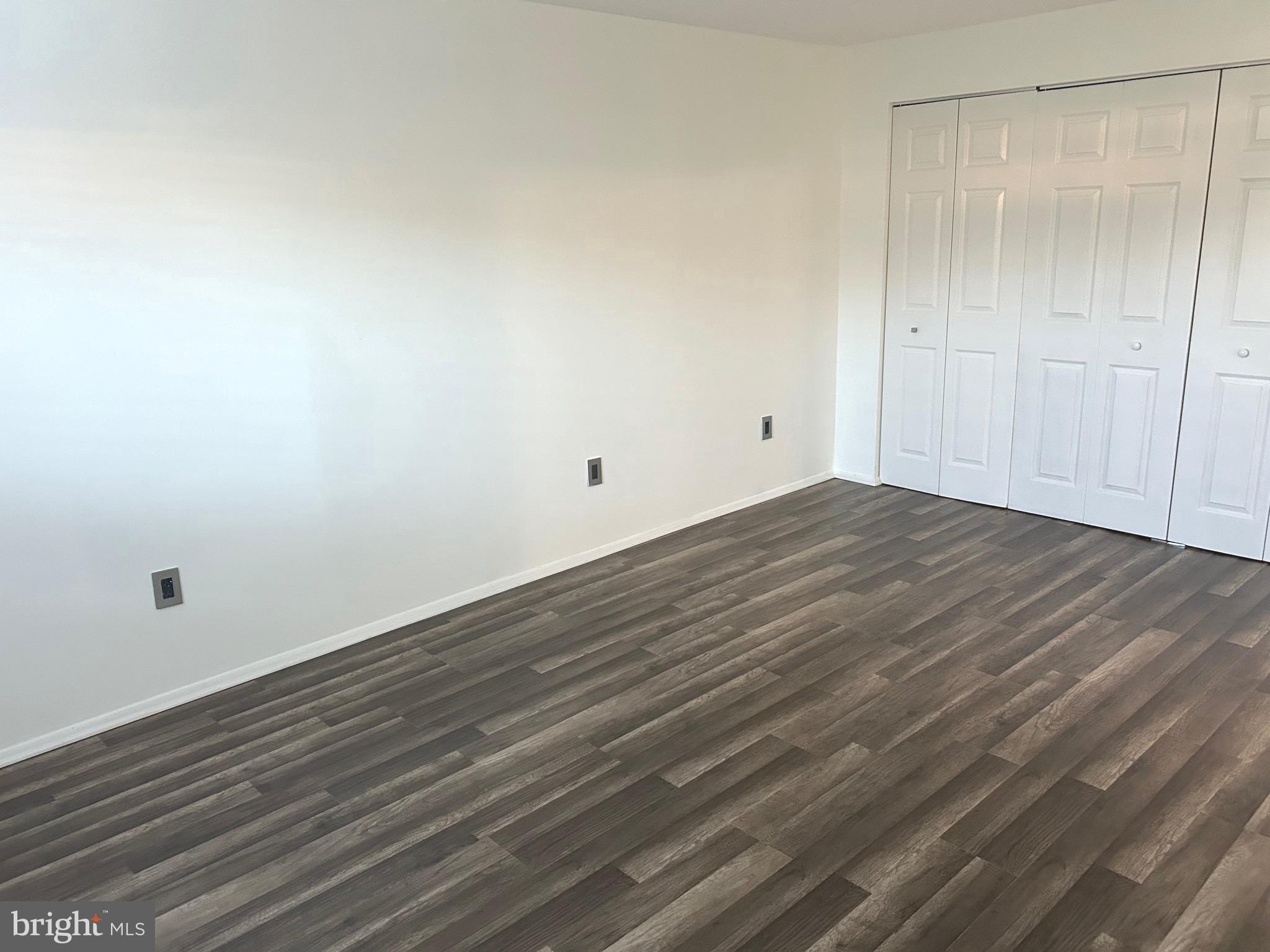 12405 Hickory Tree Way, Unit 613 Germantown, MD 20874 - Photo 25 of 39 a view of an empty room with wooden floor