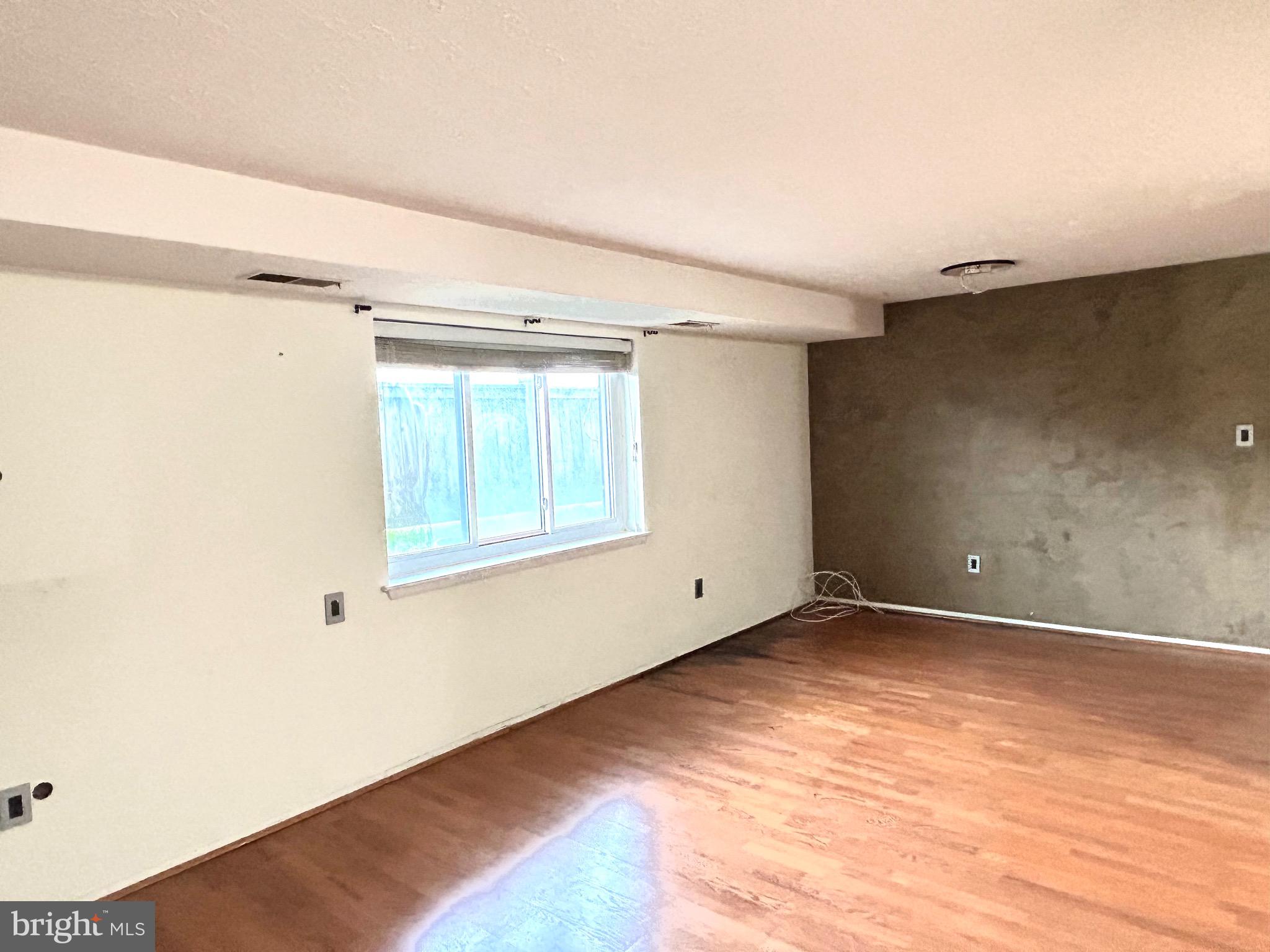 12405 Hickory Tree Way, Unit 613 Germantown, MD 20874 - Photo 35 of 39 a view of an empty room with wooden floor and a window