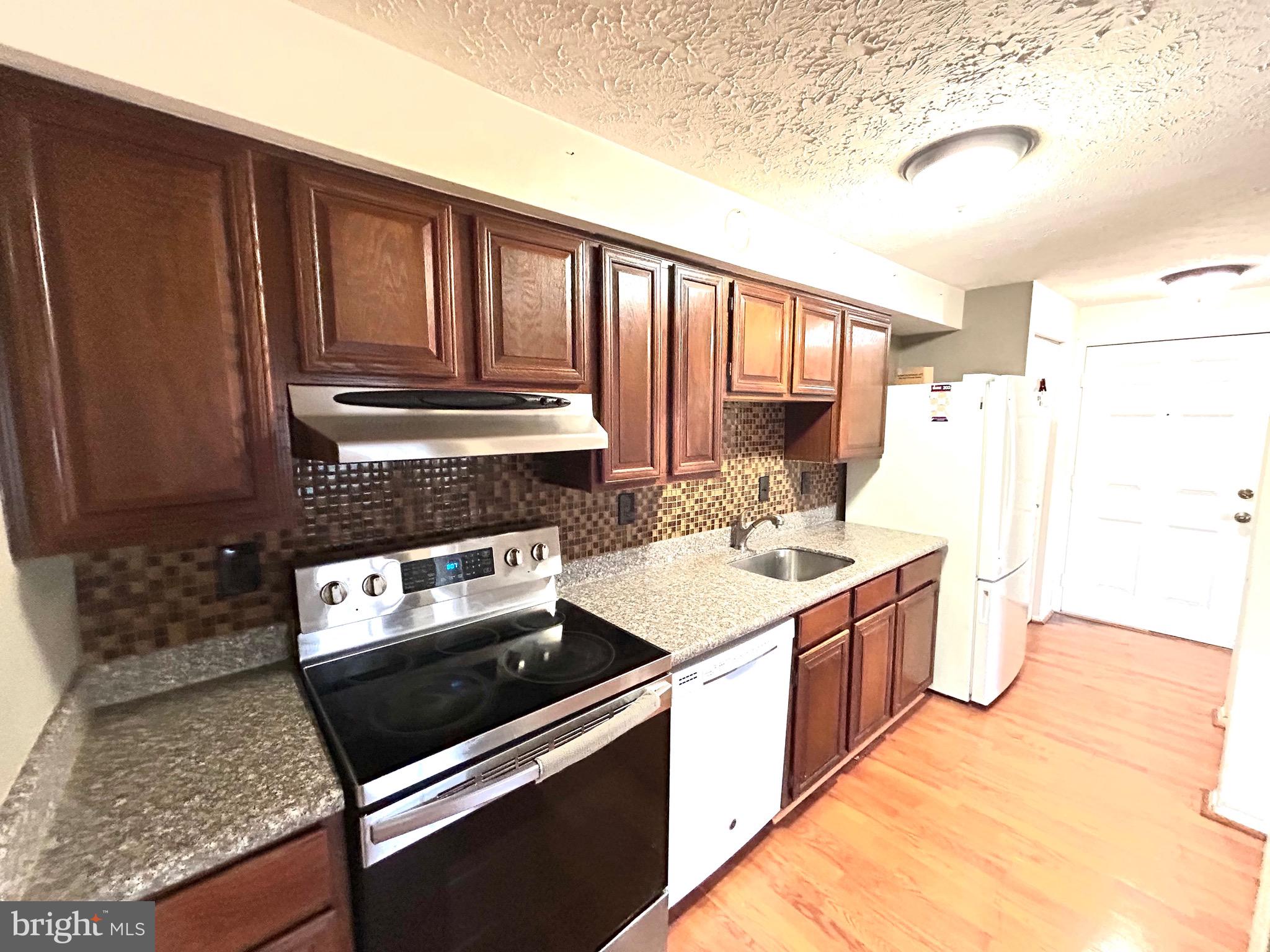 12405 Hickory Tree Way, Unit 613 Germantown, MD 20874 - Photo 36 of 39 a kitchen with a stove a sink and a refrigerator