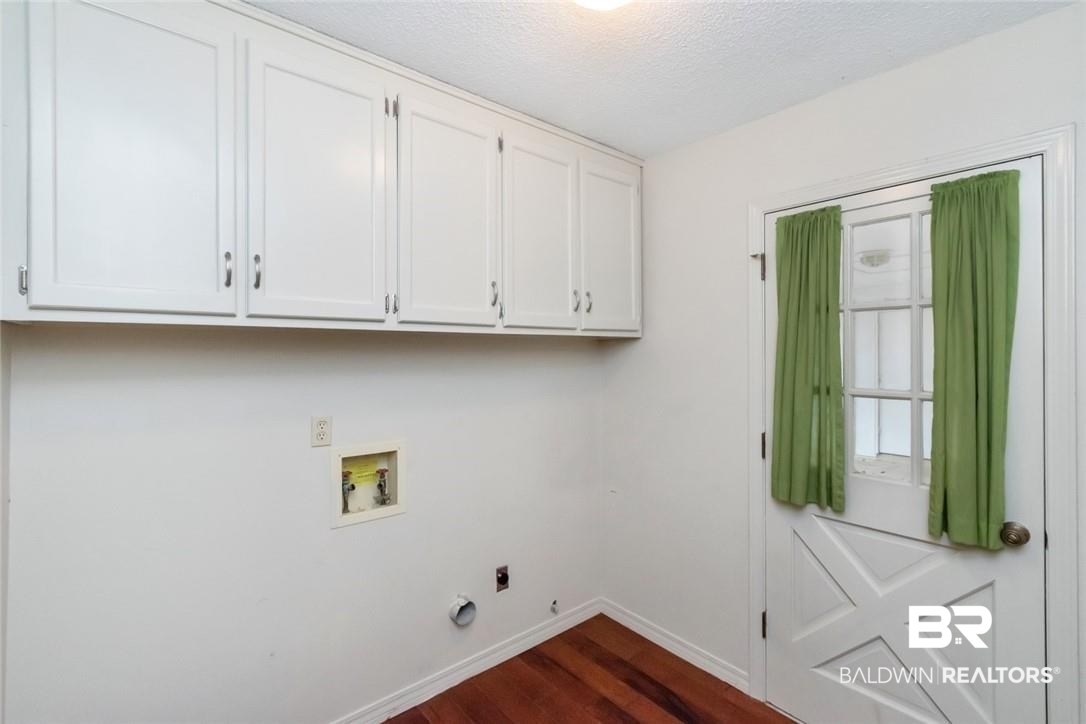 6109 Timberly Road North Mobile, AL 36609 - Photo 24 of 26 Clothes washing area featuring hookup for a washing machine, a textured ceiling, electric dryer hookup, cabinets, and dark hardwood / wood-style floors