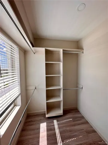 a room with walk in closet and wooden floor