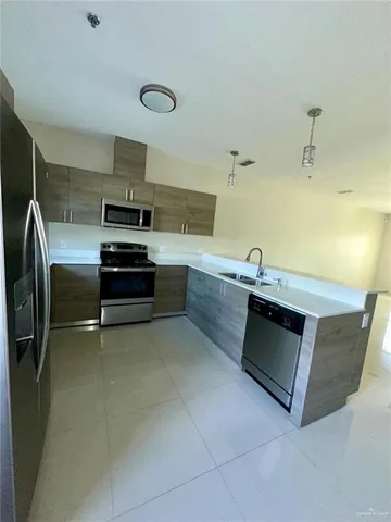 a kitchen with stainless steel appliances a stove a sink and white cabinets