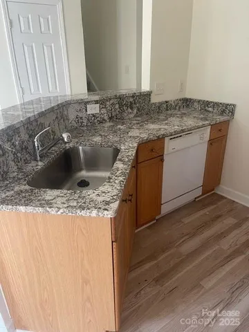 a kitchen with granite countertop a sink and a stove