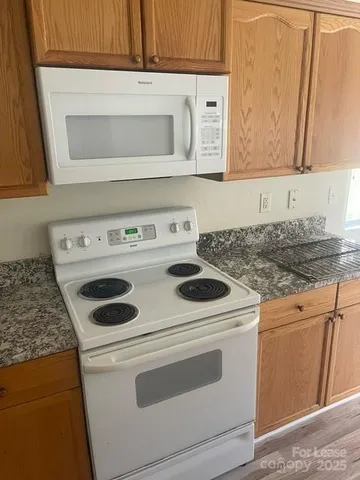 a white stove top oven sitting inside of a kitchen