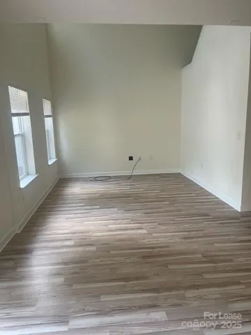 a view of empty room with window and wooden floor