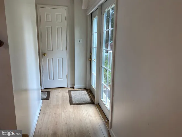 a view of a hallway with wooden floor and a window