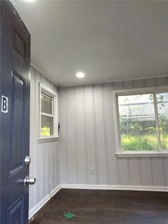 an empty room with wooden floor and entrance