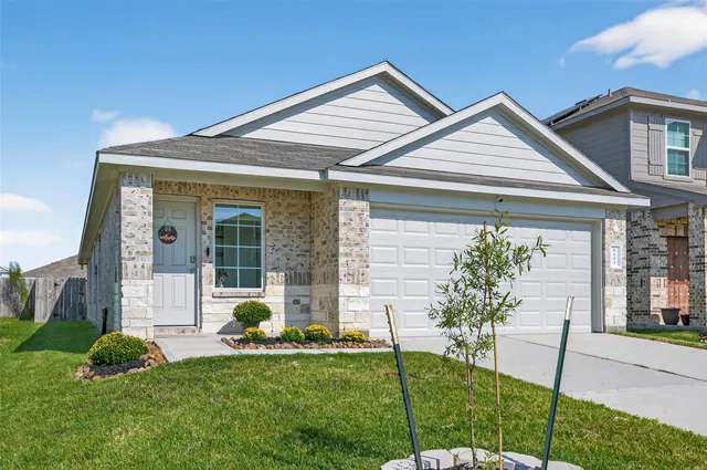 a front view of a house with a garden and plants