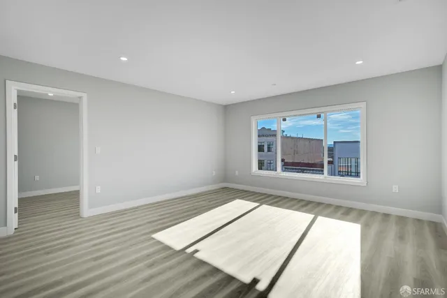 a view of a room with wooden floor and a window