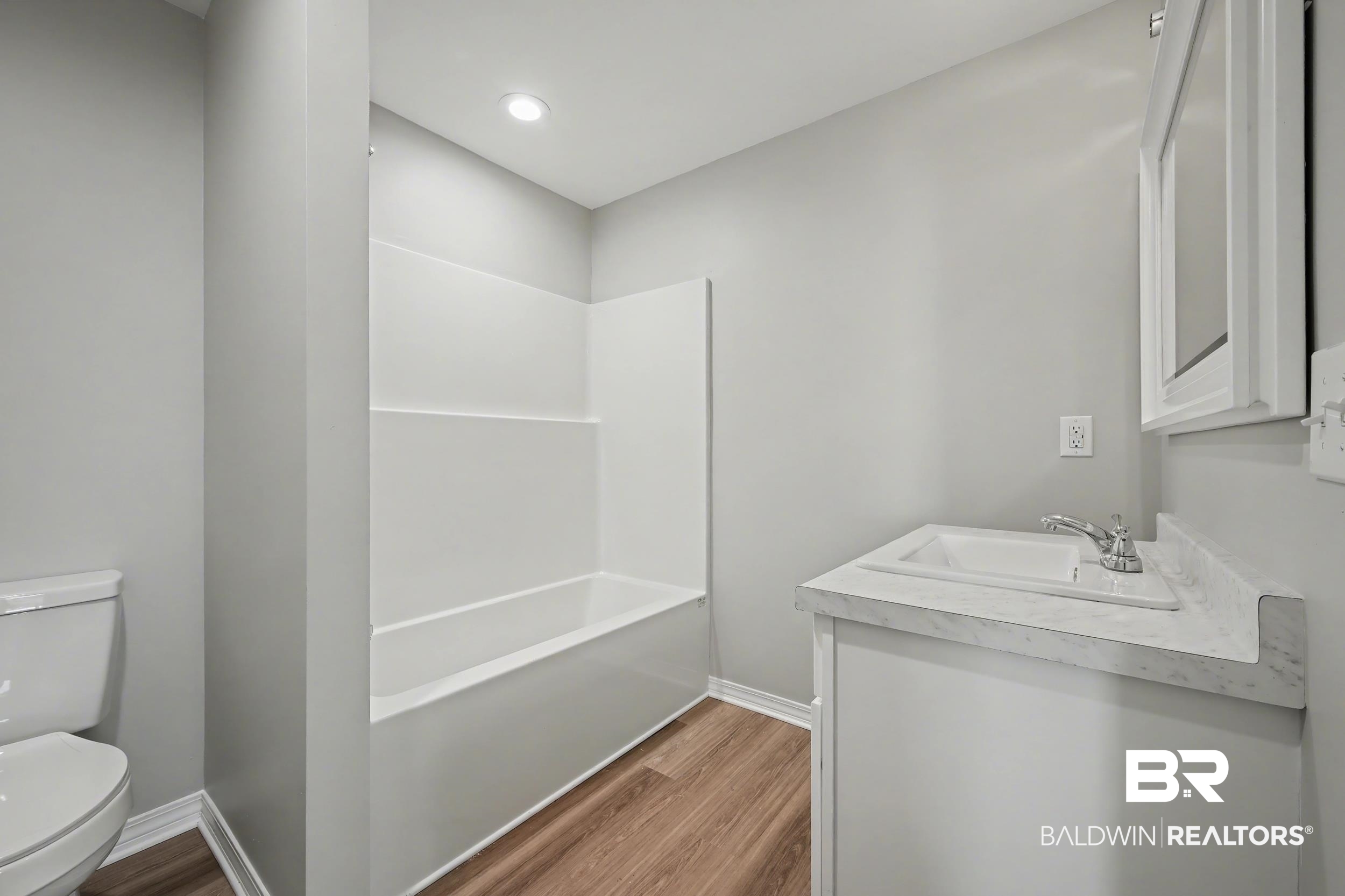 76 Fincher Lane Loxley, AL 36551 - Photo 20 of 33 Bathroom with vanity, light wood-style flooring, shower combination, and recessed lighting