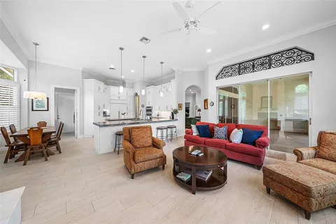 a living room with furniture a flat screen tv and a large window