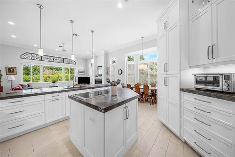 a bathroom with a granite countertop double vanity sink a mirror and a bathtub