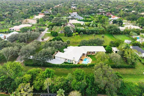 an aerial view of a house with yard green space and lake view