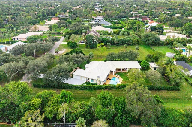 an aerial view of a house with yard green space and lake view
