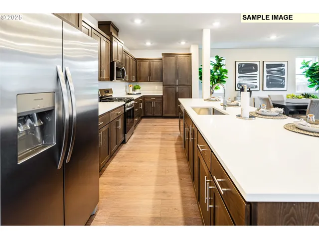 a kitchen with kitchen island a counter top space a sink stainless steel appliances and cabinets