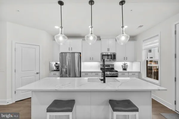 a large kitchen with a lot of counter space and wooden floor
