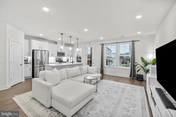 a living room with furniture a flat screen tv and a large window