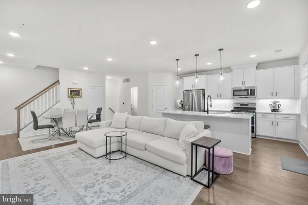 a living room with furniture and kitchen view