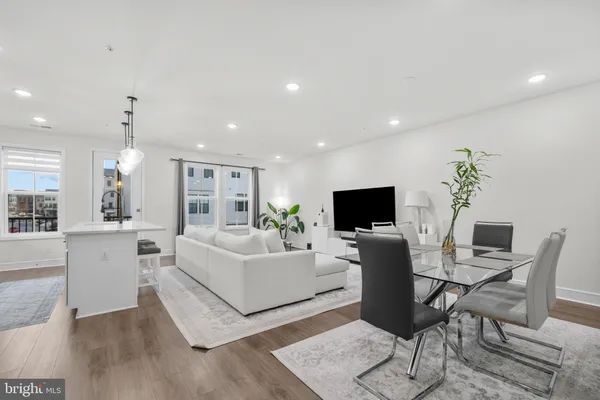 a living room with furniture a flat screen tv and kitchen view