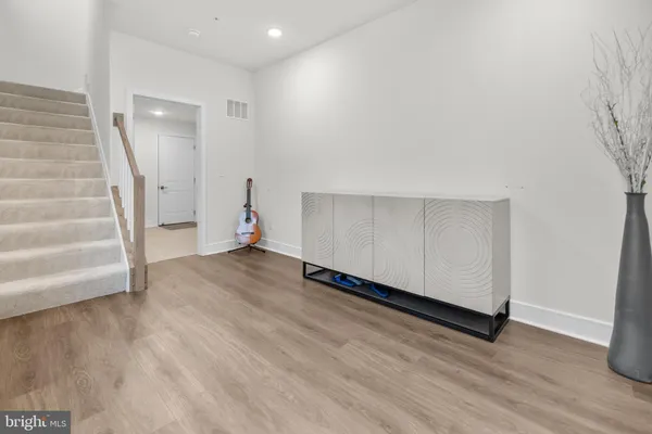 a view of a hallway with wooden floor and staircase