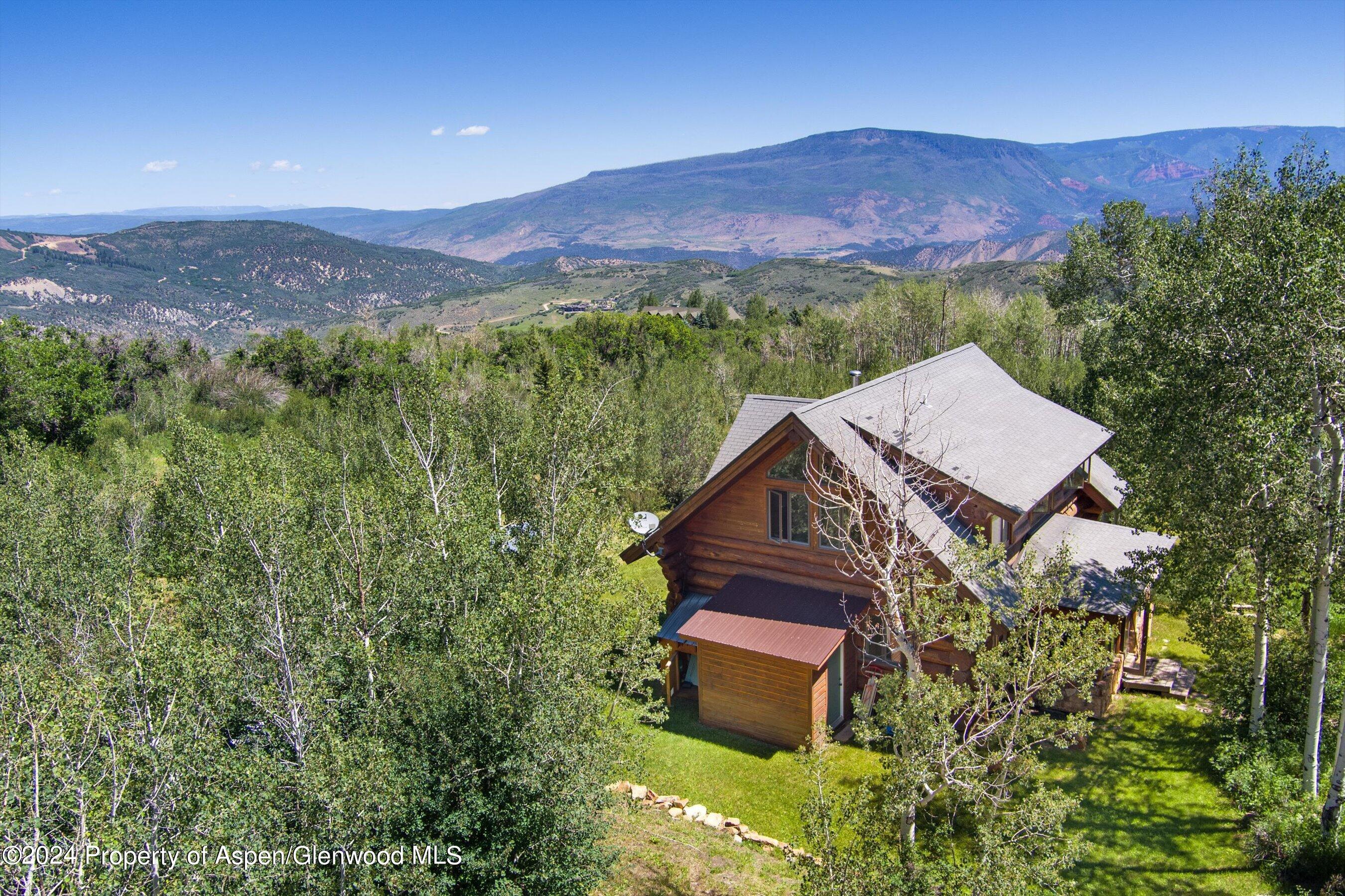 4275 Sopris Mountain Ranch Road Basalt, CO 81621 - Photo 29 of 36 a view of a lush green hillside and a houses