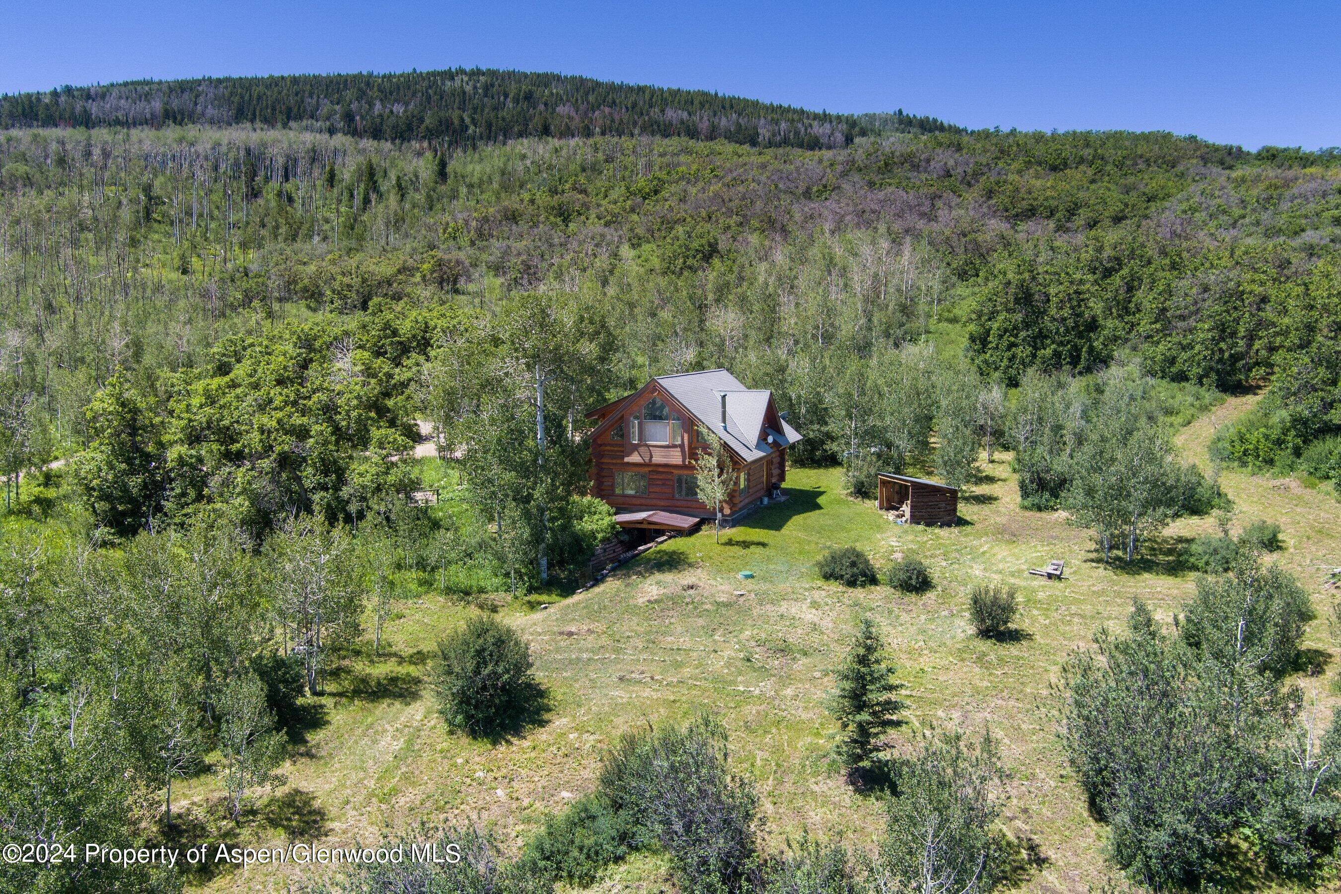 4275 Sopris Mountain Ranch Road Basalt, CO 81621 - Photo 32 of 36 a view of a lush green forest with trees and some houses