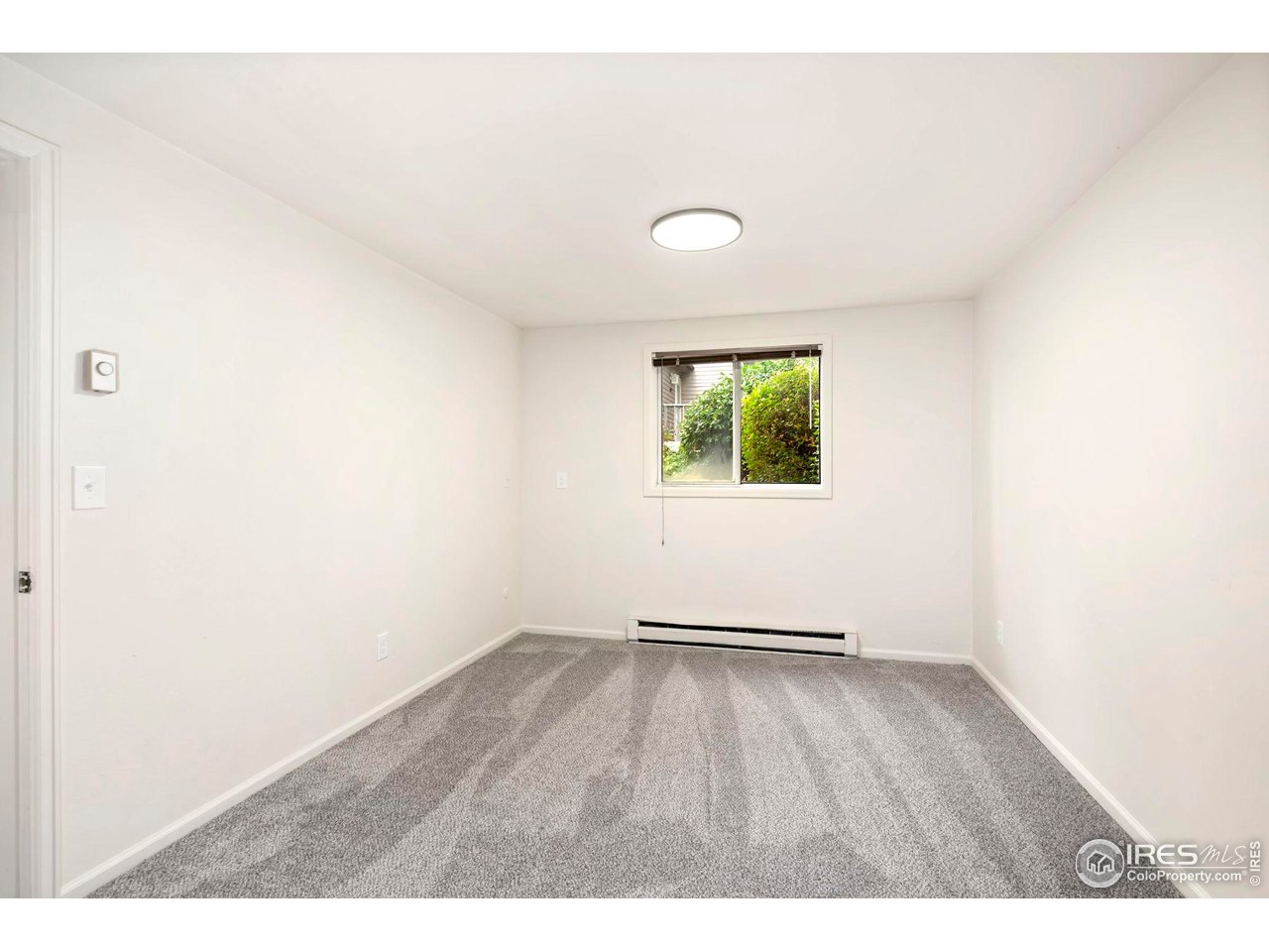 2828 Silverplume Drive, Unit R3 Fort Collins, CO 80526 - Photo 26 of 45 a view of an empty room with wooden floor and a window