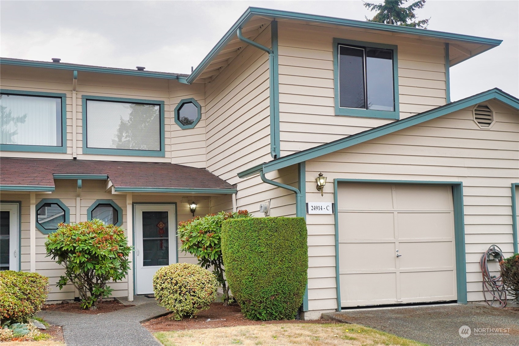 24914 109th Place Southeast, Unit 34C Kent, WA 98030 - Photo 2 of 38 a front view of a house with a garden