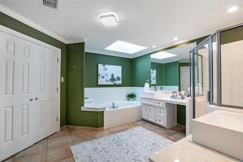 a spacious bathroom with a tub sink and mirror