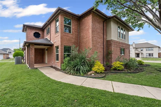 a front view of a house with a garden and plants
