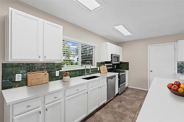 a kitchen with a sink a stove and cabinets