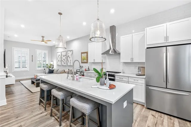 a kitchen with a refrigerator a stove a sink dishwasher white and a dining table with chairs