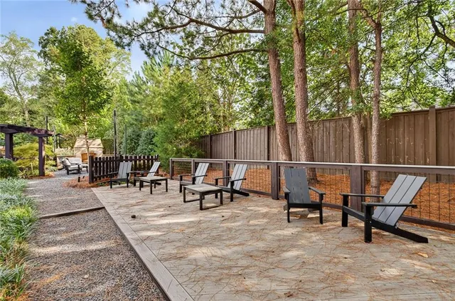 a view of a patio with table and chairs and wooden fence