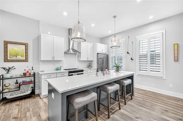 a kitchen with kitchen island a wooden floor and white appliances